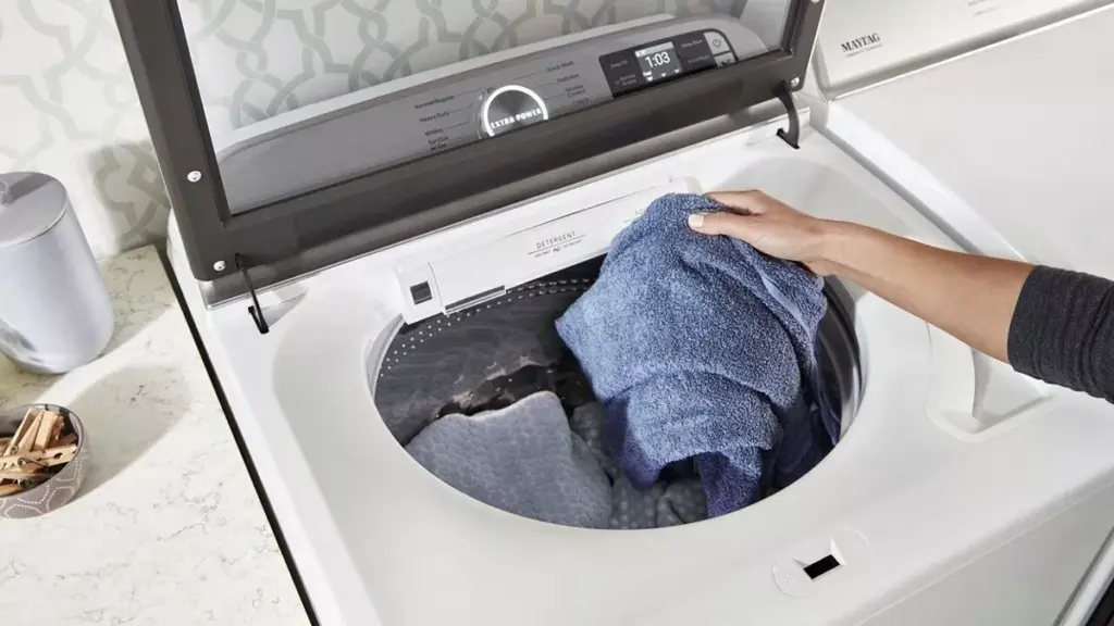 Pessoal colocando roupas em máquina de lavar 12kg