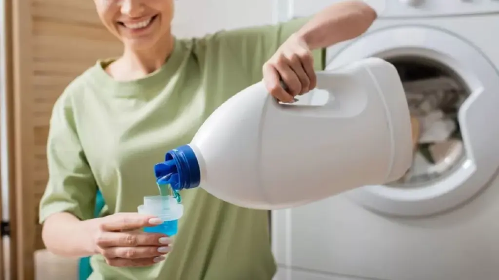 Mulher despejando amaciante em tampinha