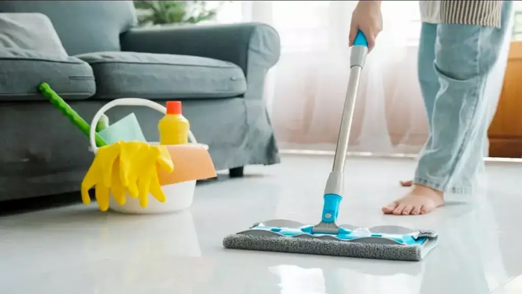 Mulher limpando a casa com produto para limpar porcelanato