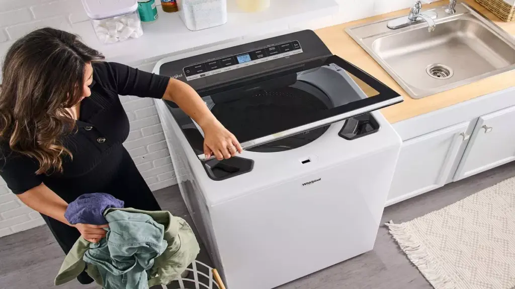 Mulher abrindo máquina de lavar